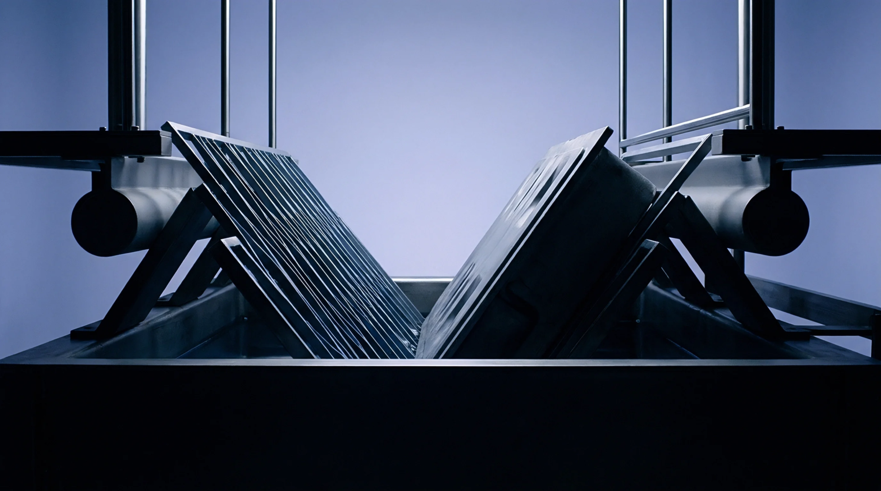 Two textured tooling plates are held in a symmetrical V shape while partially submerged in a dark liquid coating bath.